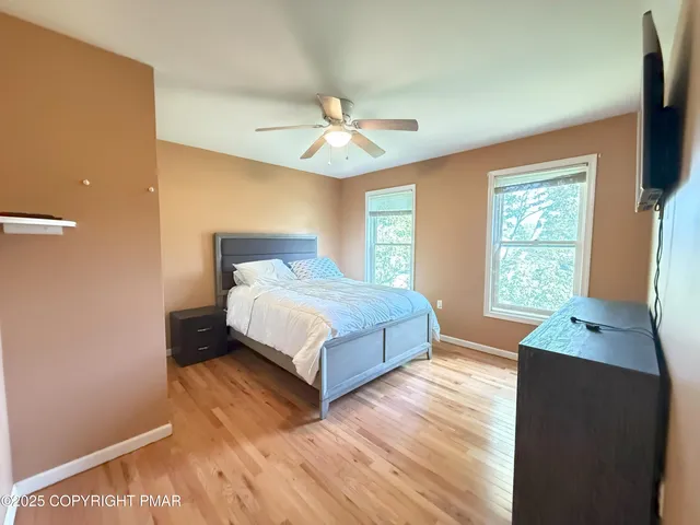 a bedroom with a bed and a flat tv screen on dresser