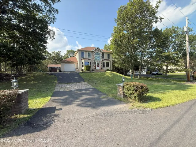 a view of outdoor space with sign board and large trees