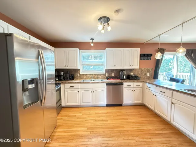 a kitchen with stainless steel appliances granite countertop a refrigerator sink and cabinets