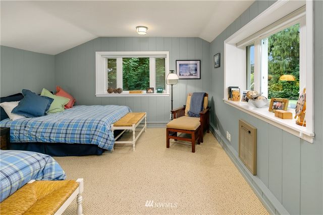 a bedroom with a bed chair and a window