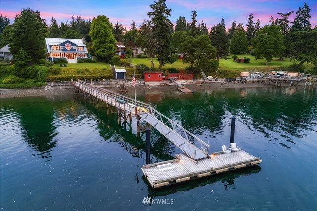 an aerial view of a house with outdoor space and lake view in back