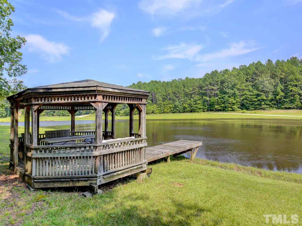4040 Pine Ridge Road Franklinton, NC 27525 - Photo 30 of 30 a view of a house with a wooden deck and a lake view