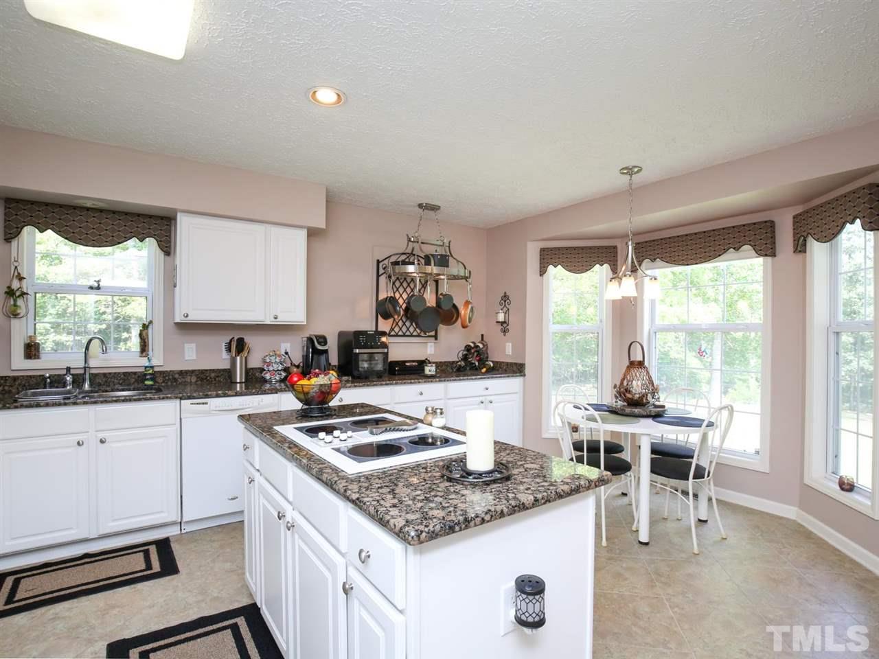 4040 Pine Ridge Road Franklinton, NC 27525 - Photo 7 of 30 a kitchen with granite countertop a sink stove and cabinets