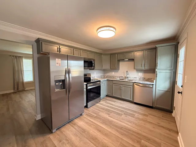 a kitchen with a refrigerator a sink and a stove top oven