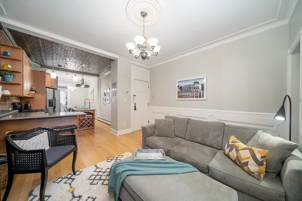 a living room with furniture a chandelier and a dining table