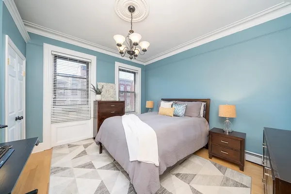 a spacious bedroom with a bed and a chandelier