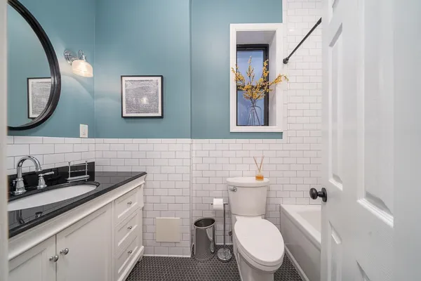 a bathroom with a toilet a sink and mirror