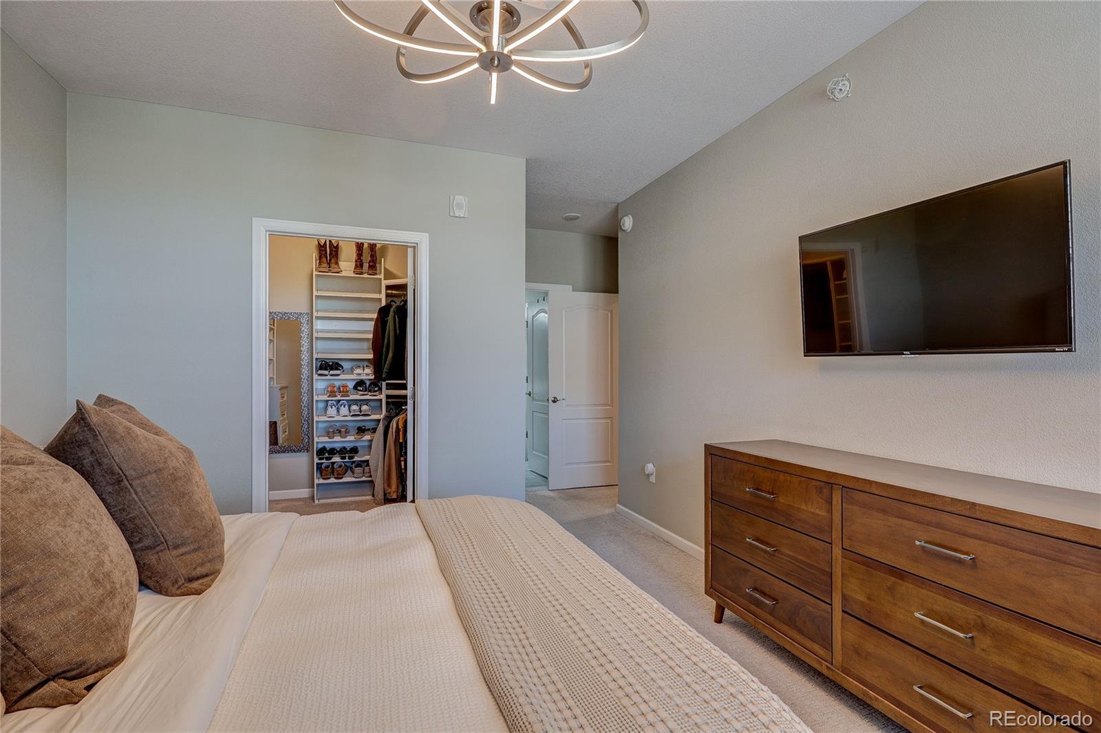 4777 Copeland Circle, Unit 204 Highlands Ranch, CO 80126 - Photo 17 of 39 a bedroom with a bed and a flat screen tv