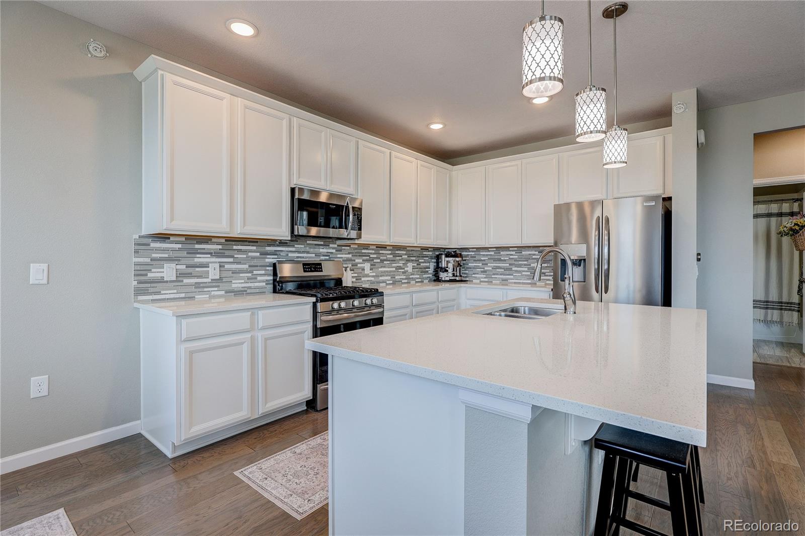 4777 Copeland Circle, Unit 204 Highlands Ranch, CO 80126 - Photo 6 of 39 a kitchen with kitchen island a white counter top space cabinets and stainless steel appliances