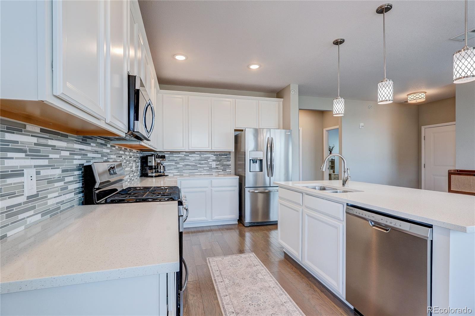 4777 Copeland Circle, Unit 204 Highlands Ranch, CO 80126 - Photo 7 of 39 a kitchen with stainless steel appliances granite countertop a sink a stove and a refrigerator