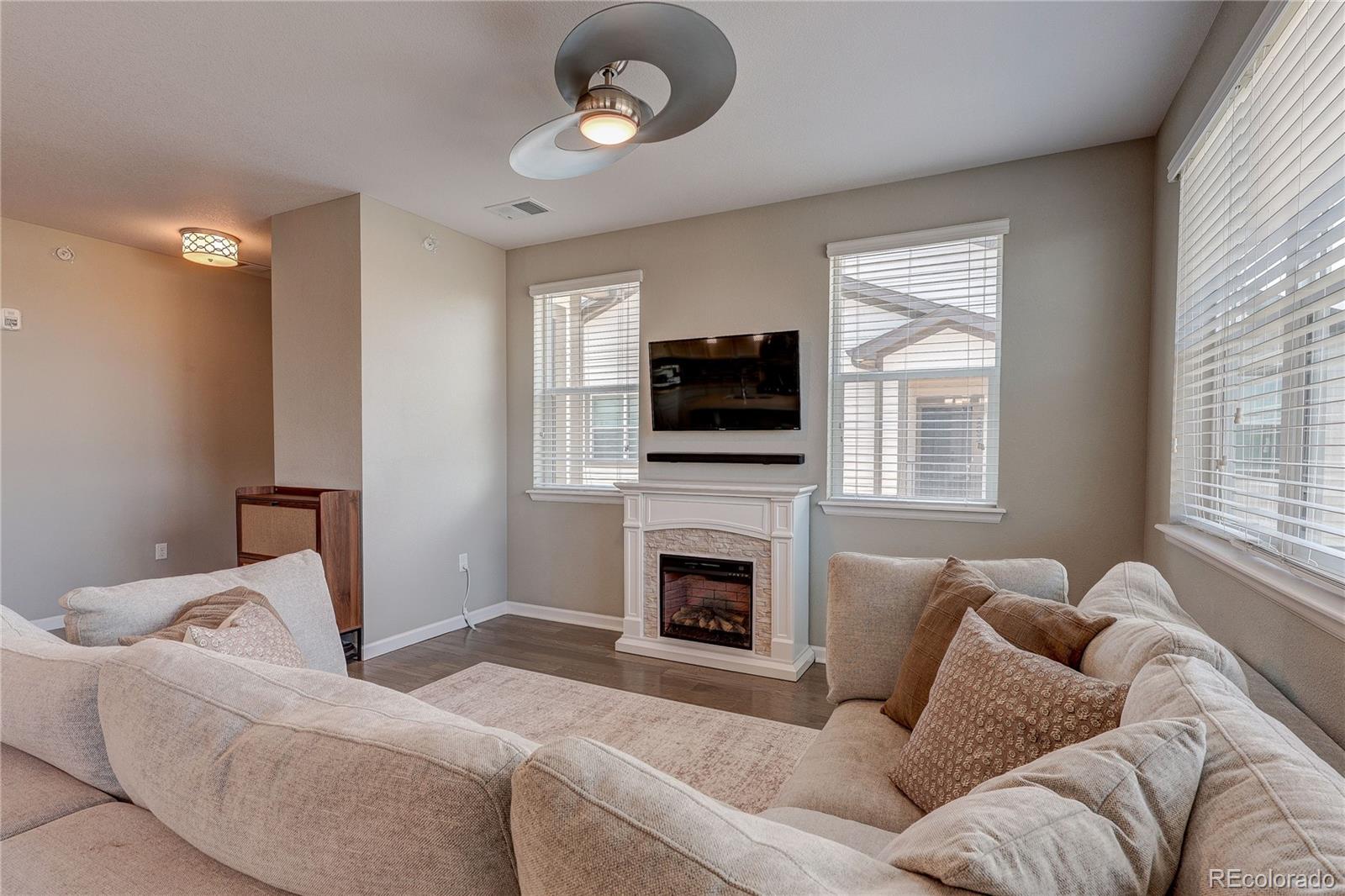 4777 Copeland Circle, Unit 204 Highlands Ranch, CO 80126 - Photo 9 of 39 a living room with furniture a fireplace and a flat screen tv