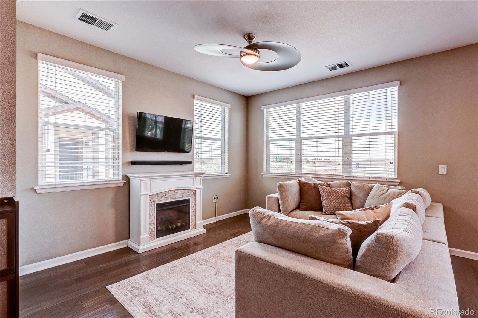 4777 Copeland Circle, Unit 204 Highlands Ranch, CO 80126 - Photo 10 of 39 a living room with furniture a fireplace and a flat screen tv