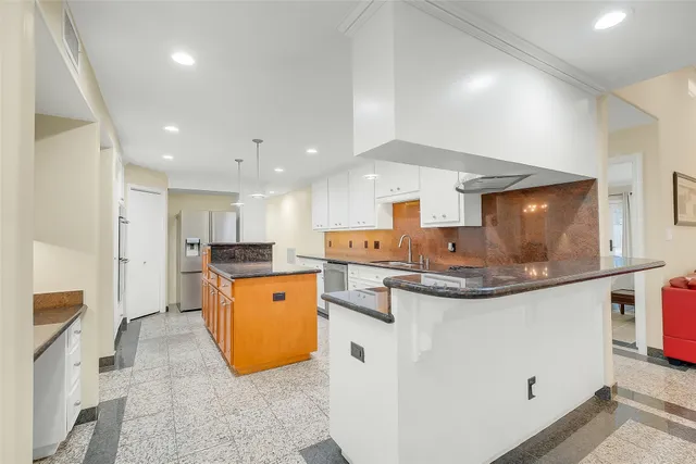 a kitchen with stainless steel appliances a stove a sink and a refrigerator