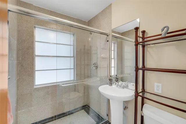 a bathroom with a sink shower and a mirror
