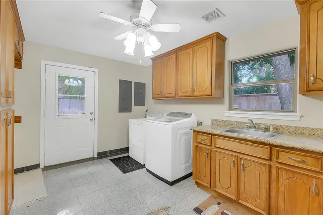 a utility room with cabinets washer and dryer