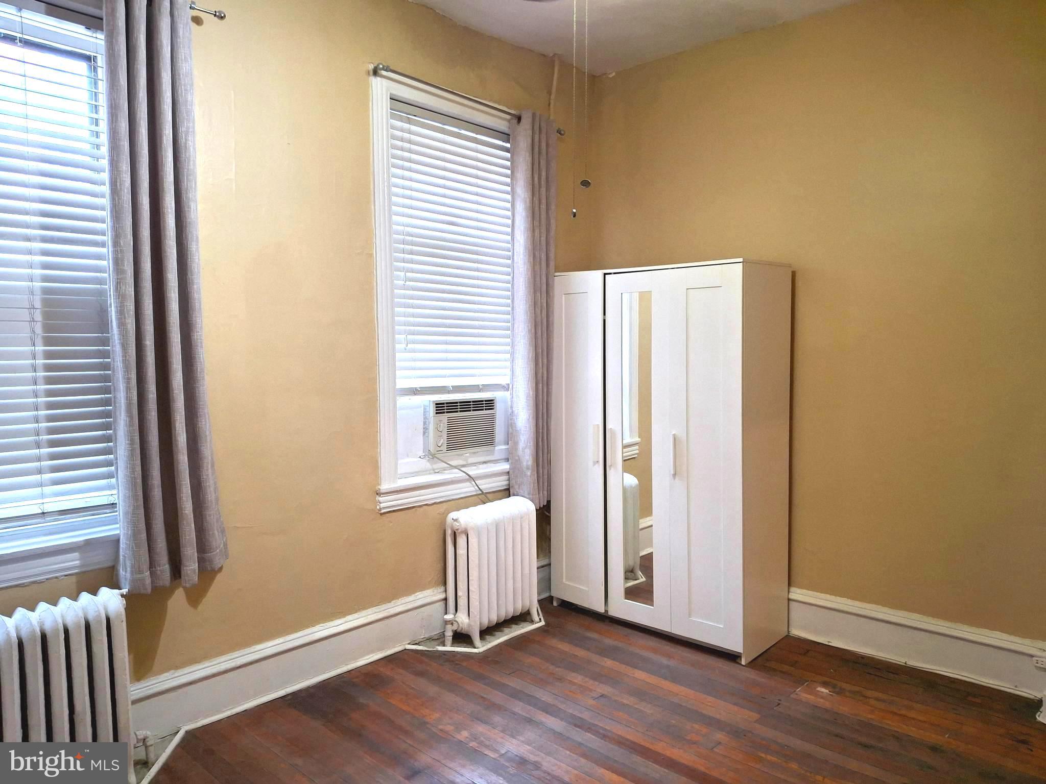 310 South 12th Street, Unit 1F Philadelphia, PA 19107 - Photo 6 of 12 an empty room with wooden floor and a window