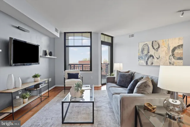 a living room with furniture a flat screen tv and a large window