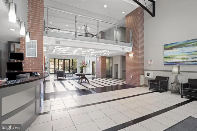 a living room with stainless steel appliances furniture and a kitchen view