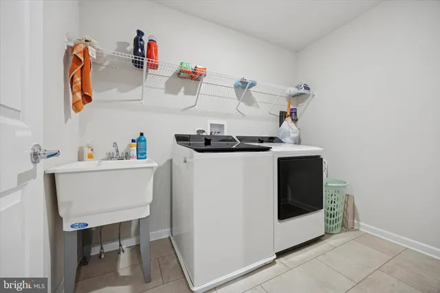 a utility room with sink dryer and washer