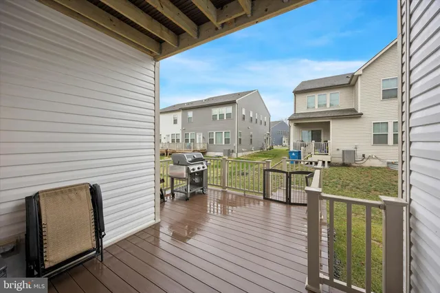 a view of a patio with table and chairs with wooden floor and fence