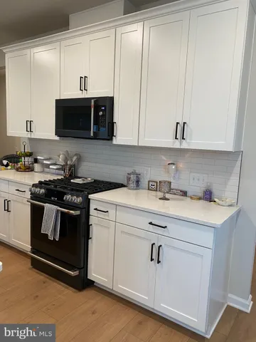 a kitchen with stainless steel appliances white cabinets and a sink