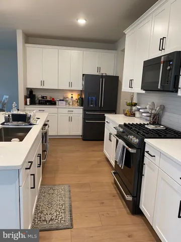 a kitchen with cabinets stainless steel appliances and a counter space