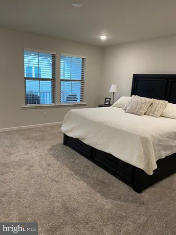 a large bed sitting in a bedroom next to a window
