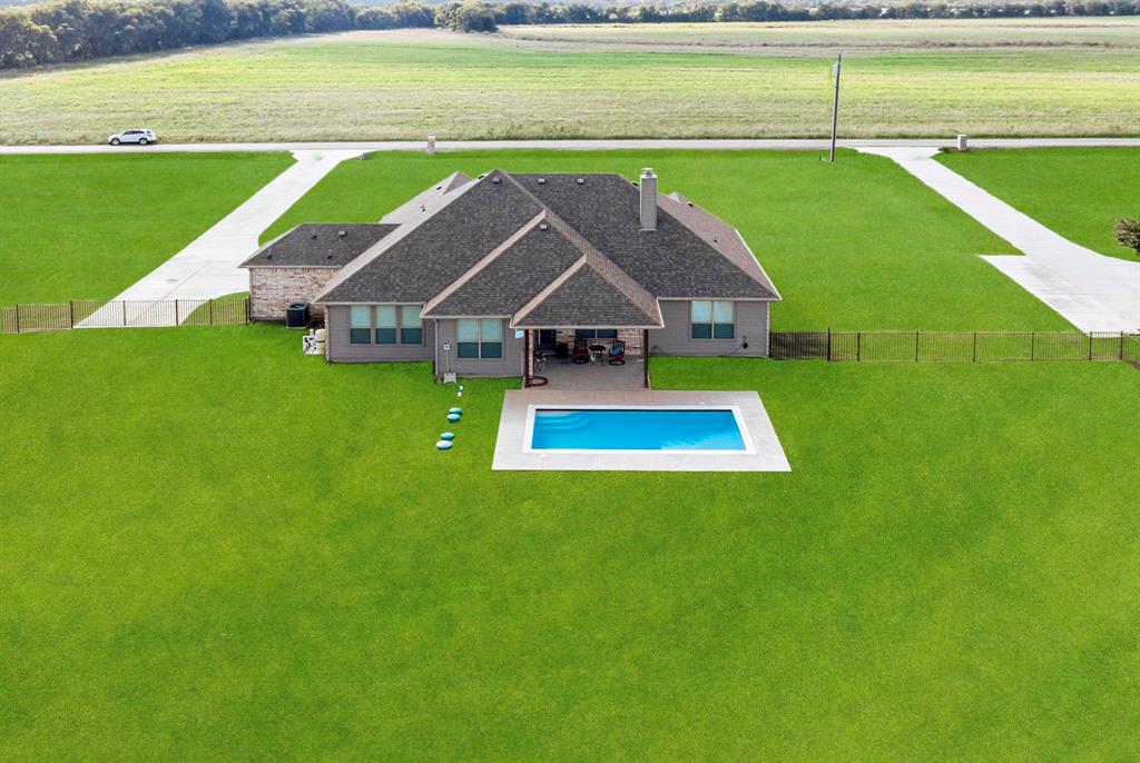 634 Gant Road Sherman, TX 75090 - Photo 38 of 40 Expansive green lawn surrounds a single-story residence featuring a rectangular swimming pool with a paved surround