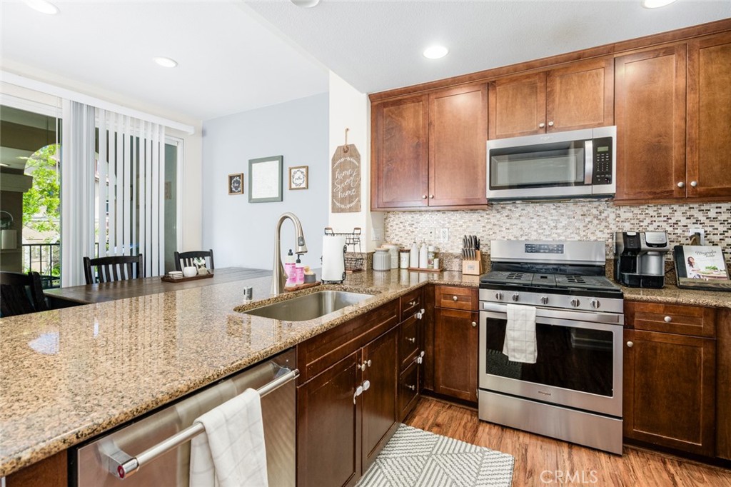 1113 Calabria Street Santee, CA 92071 - Photo 11 of 35 a kitchen with stainless steel appliances granite countertop a stove a sink and a microwave