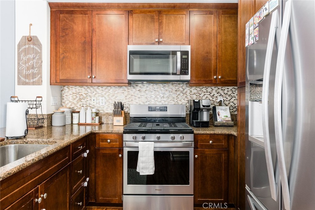 1113 Calabria Street Santee, CA 92071 - Photo 12 of 35 a kitchen with stainless steel appliances granite countertop a stove a sink and a microwave