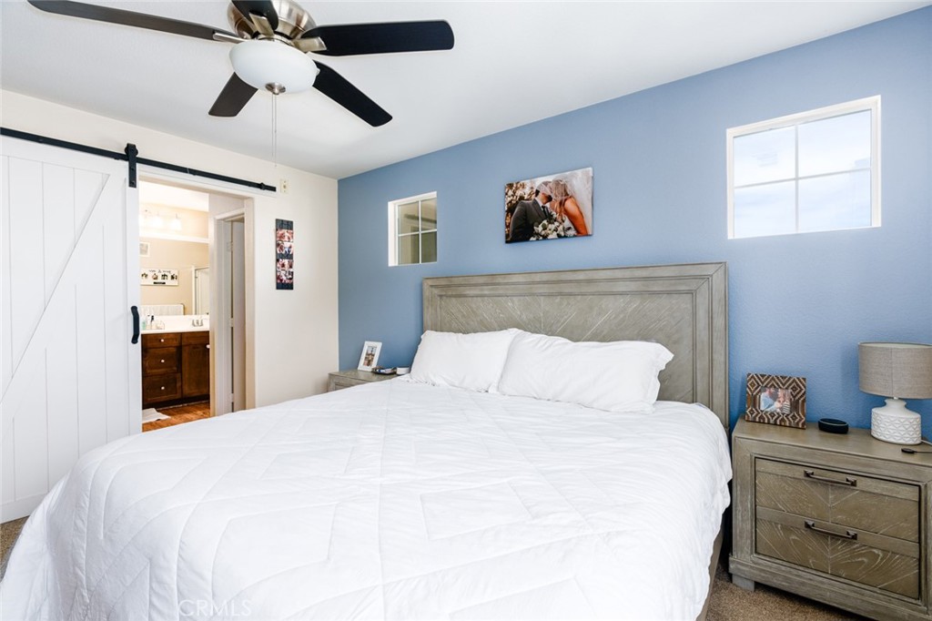 1113 Calabria Street Santee, CA 92071 - Photo 15 of 35 a bedroom with a large bed and a chandelier