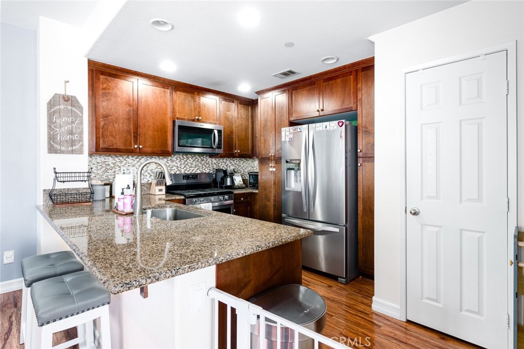 1113 Calabria Street Santee, CA 92071 - Photo 7 of 35 a kitchen with stainless steel appliances granite countertop a refrigerator a stove a sink and a microwave
