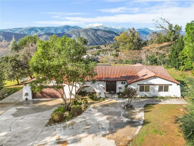 a front view of a house with a yard lake view and mountain view