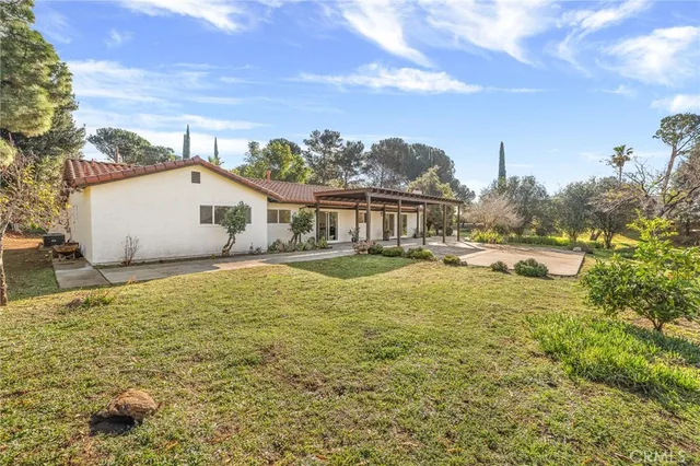 a front view of a house with a yard and trees
