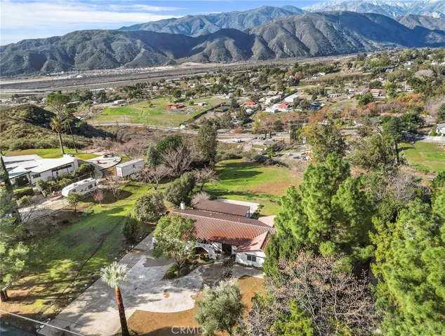 an aerial view of a house with swimming pool and garden