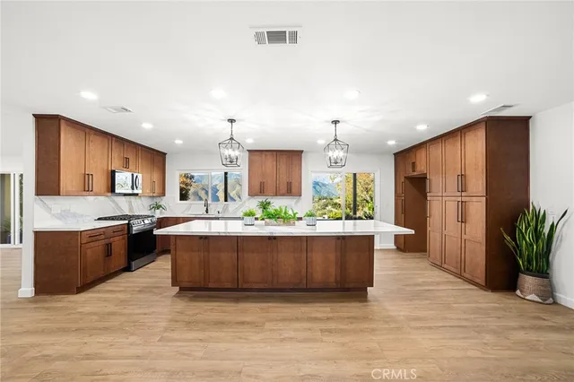 a kitchen with stainless steel appliances granite countertop a sink stove and refrigerator