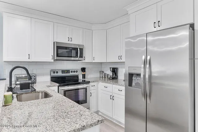 a kitchen with stainless steel appliances granite countertop a refrigerator sink and cabinets