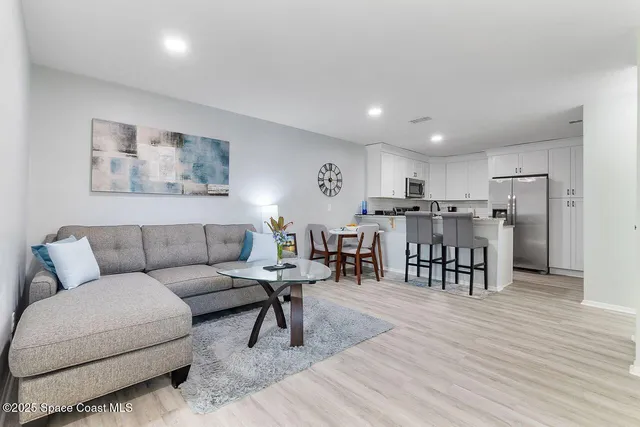 a living room with furniture and kitchen view