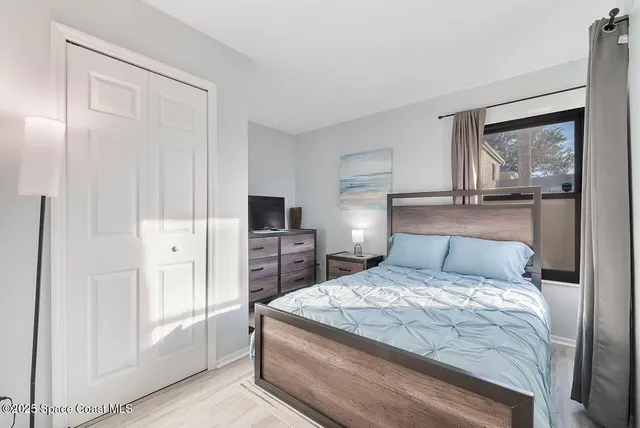 a bedroom with a bed and a painting on the wall