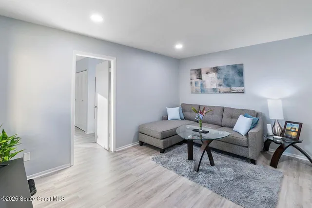 a living room with furniture and a wooden floor