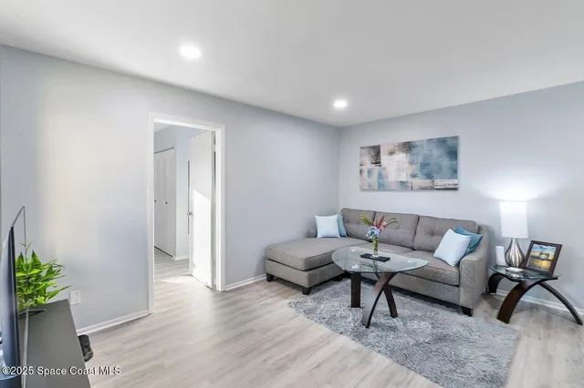 a living room with furniture and a potted plant