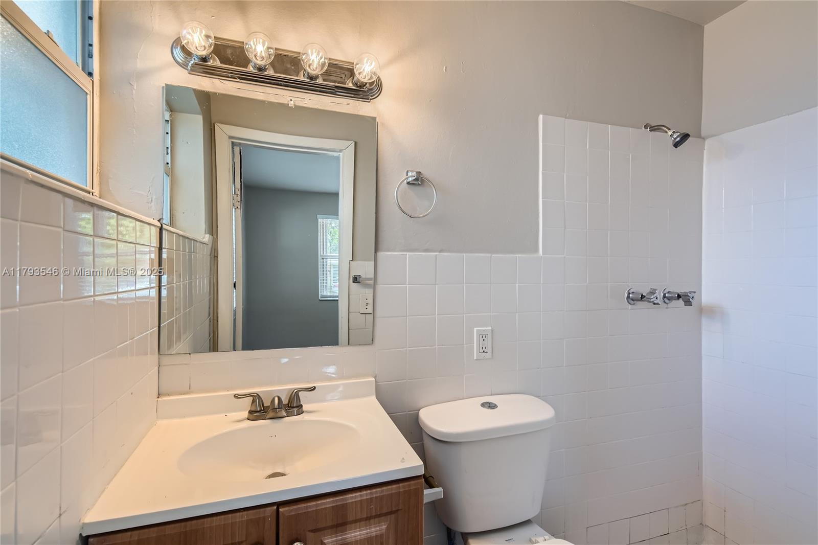 6437 Custer Street Hollywood, FL 33024 - Photo 12 of 22 a bathroom with a toilet sink and mirror