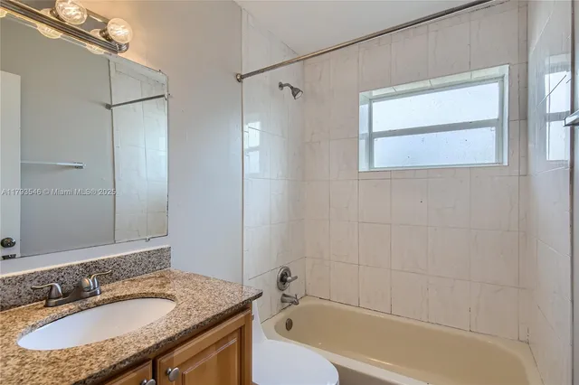 an empty room with a ceiling fan and window