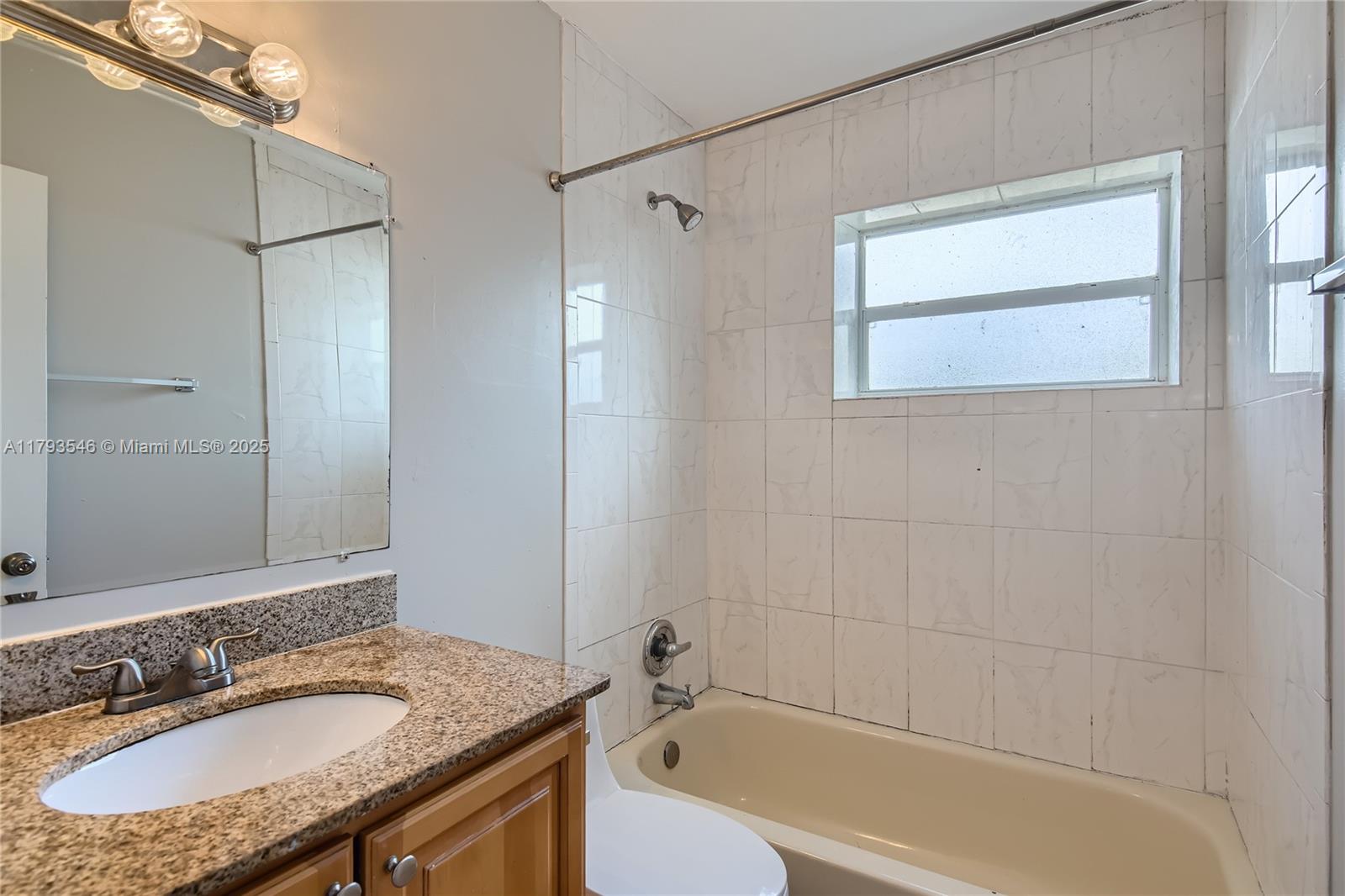 6437 Custer Street Hollywood, FL 33024 - Photo 15 of 22 a bathroom with a granite countertop sink mirror bathtub and shower