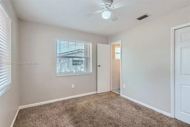 a view of livingroom with a chandelier fan and a bathroom