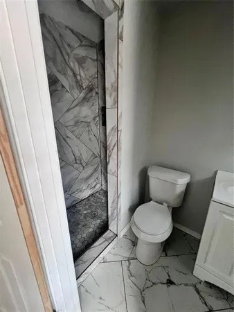 a bathroom with a toilet and a shower