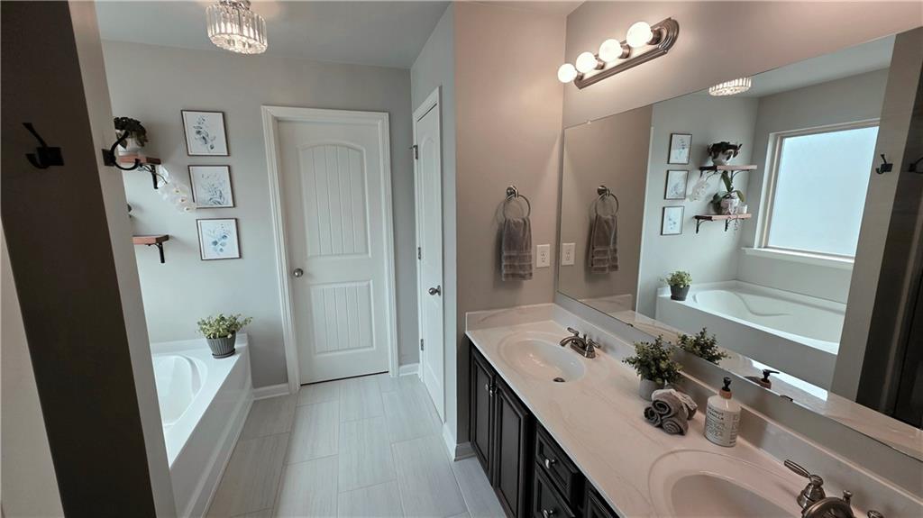 303 High Water Court Acworth, GA 30102 - Photo 12 of 27 a bathroom with a tub sink and mirror