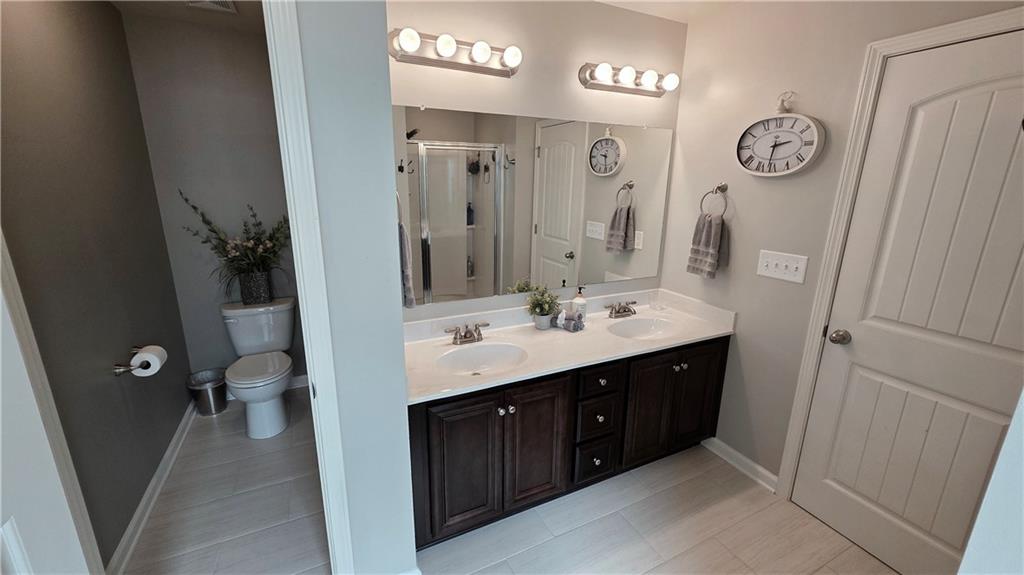 303 High Water Court Acworth, GA 30102 - Photo 13 of 27 a bathroom with a toilet sink and mirror