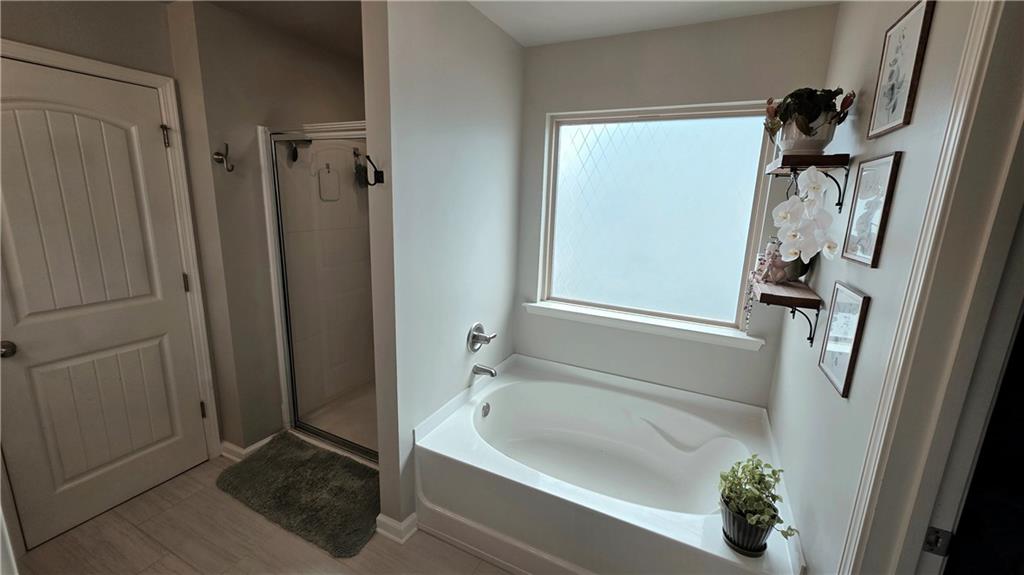 303 High Water Court Acworth, GA 30102 - Photo 14 of 27 a bathroom with a tub a window and a shower