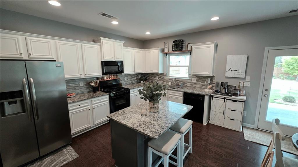 303 High Water Court Acworth, GA 30102 - Photo 6 of 27 a kitchen with granite countertop stainless steel appliances a stove refrigerator sink and cabinets